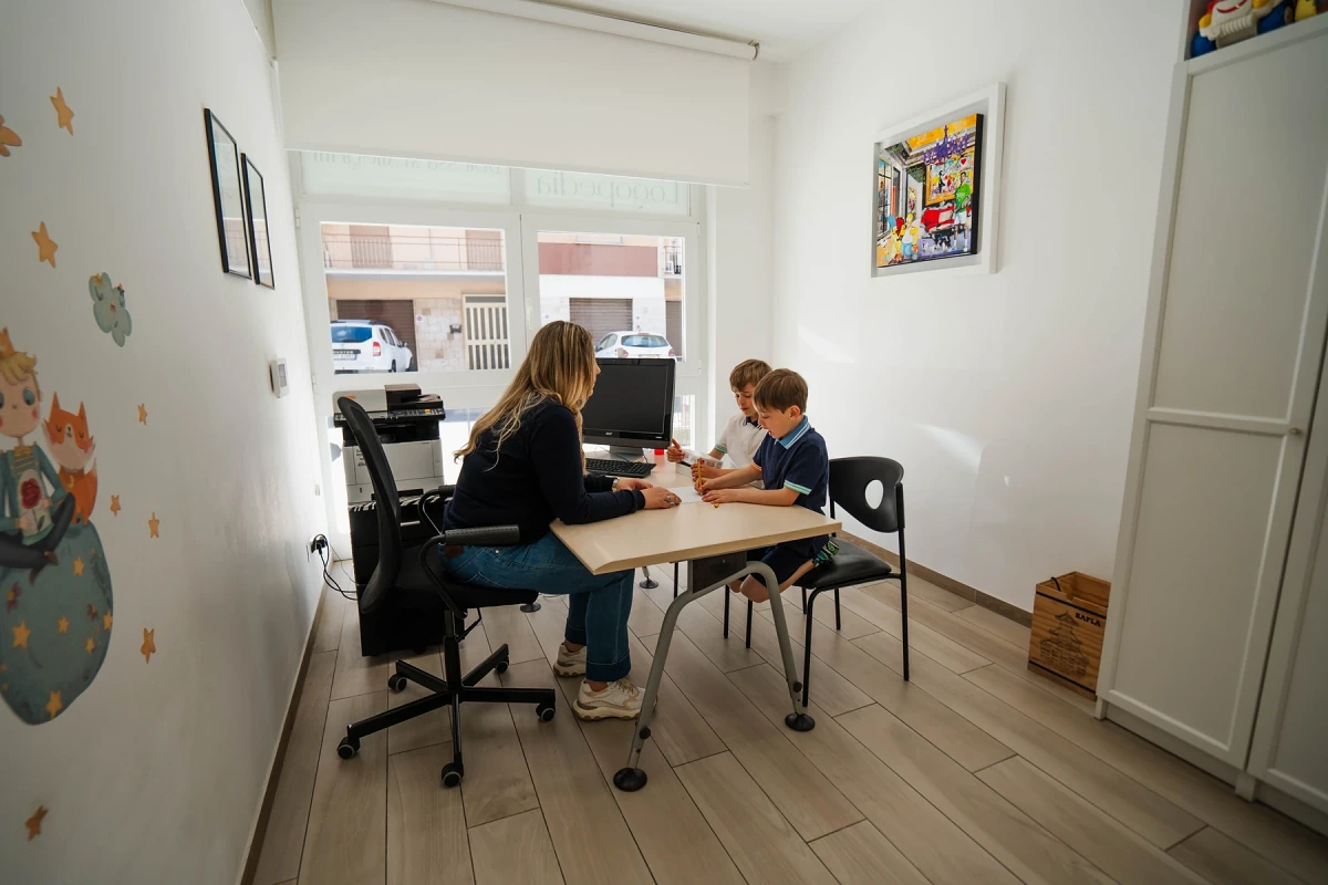 Two children working together at the table during a bilingual speech therapy session at the Viterbo practice